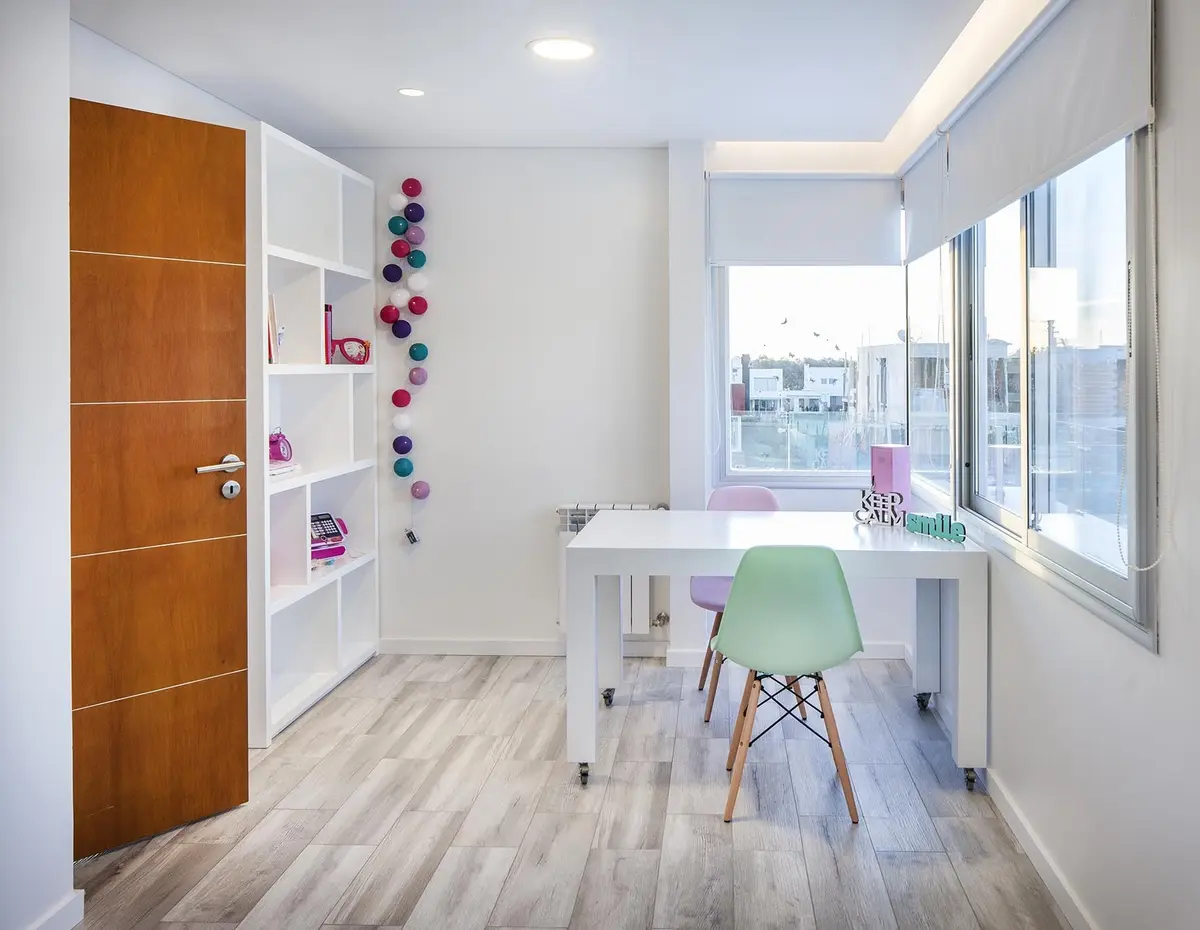 Oficina moderna con escritorio blanco y silla verde — proyecto Casa FA, por Estudio GR, en City Bell