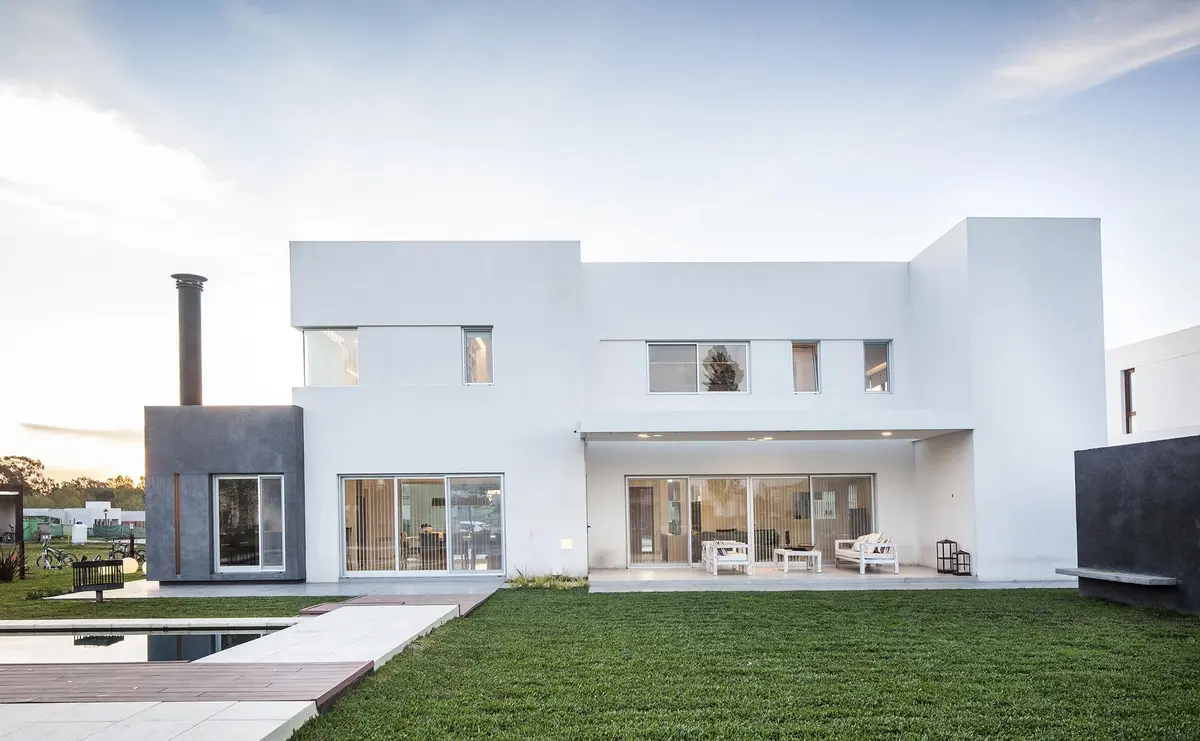 fachada moderna minimalista com contraste de concreto branco e cinza — projeto Casa FA, por Estudio GR, em City Bell