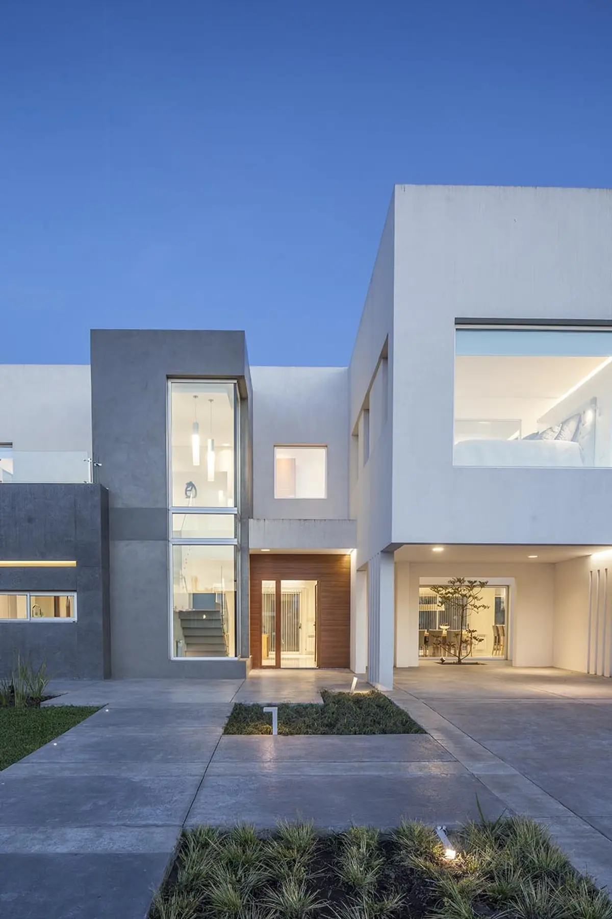 Casa moderna con volumenes de hormigón y madera, entrada vidriada — proyecto Casa FA, por Estudio GR, en City Bell