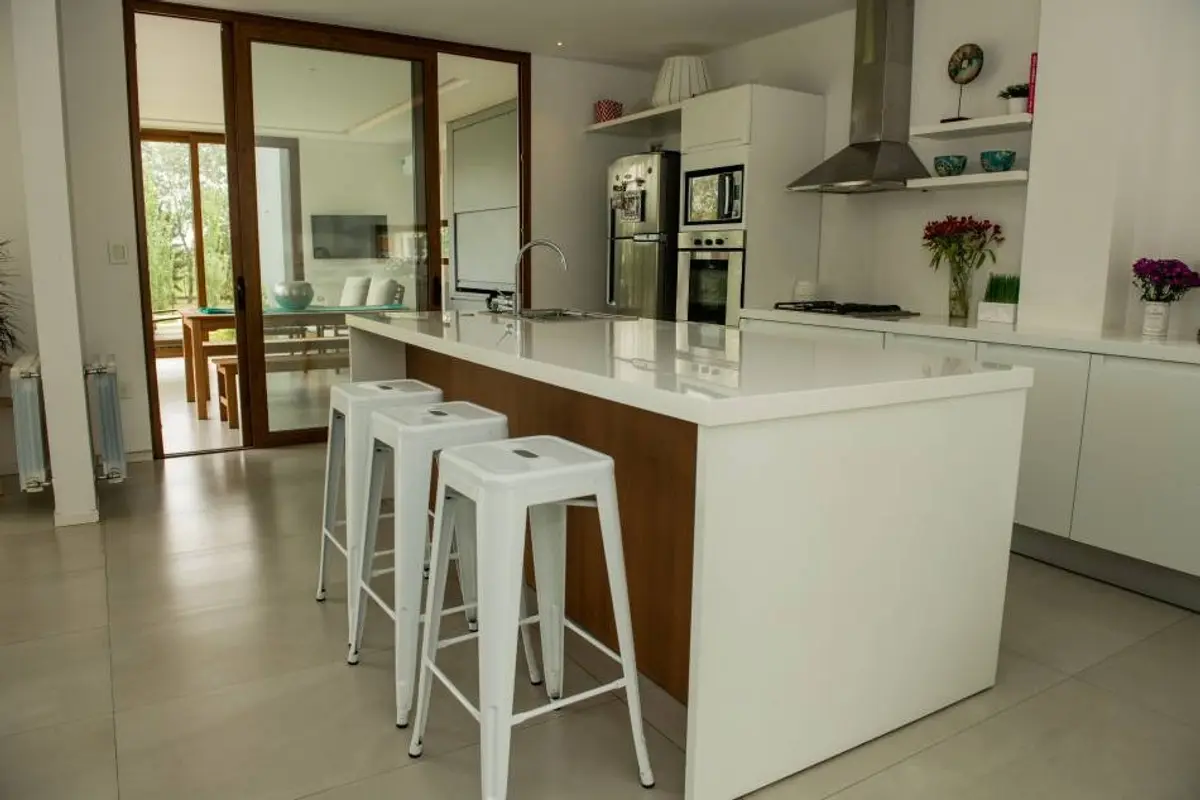 Cocina moderna y abierta con isla grande y barra — proyecto Casa ME, por Estudio GR, en City Bell