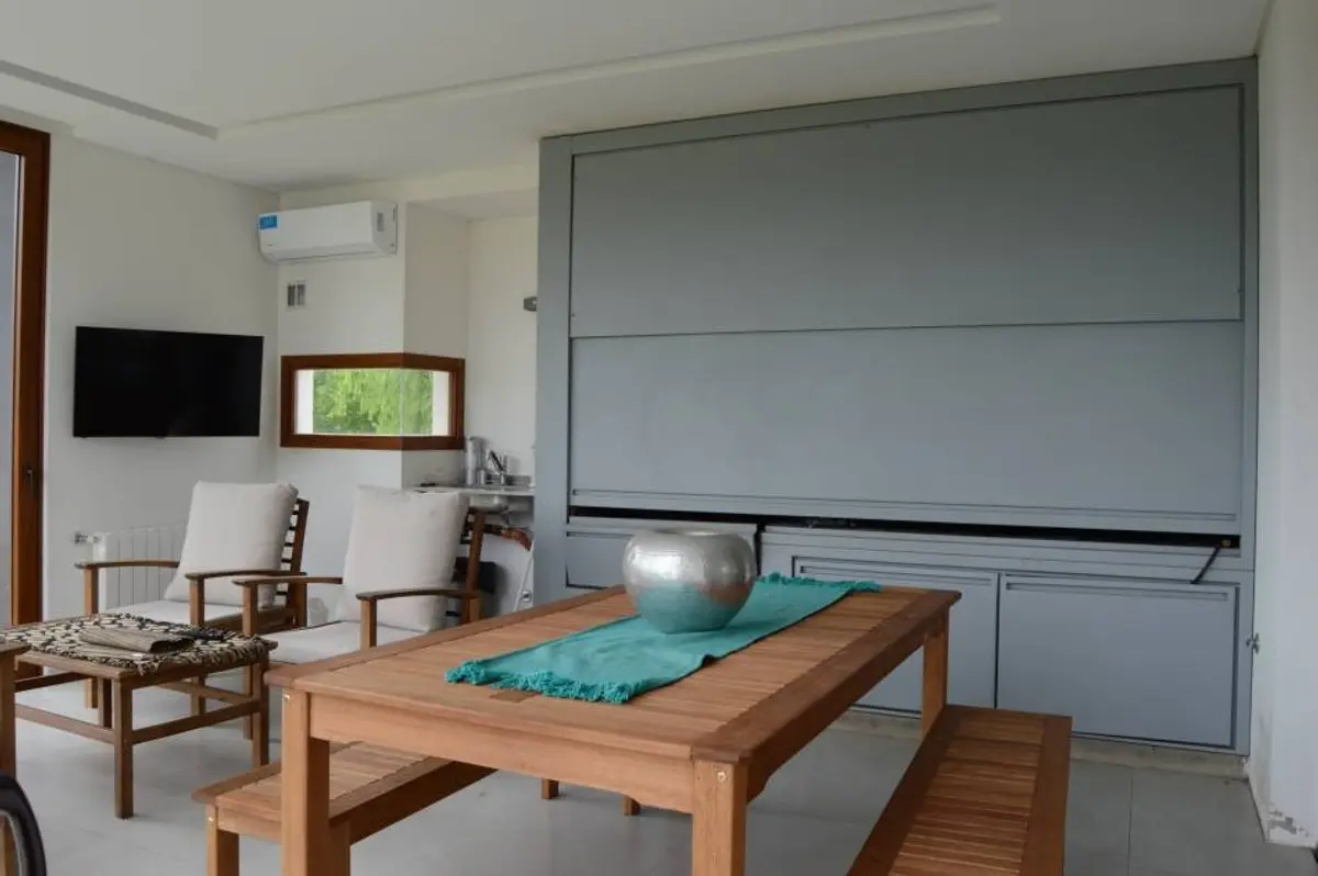 Sala de jantar moderna com mesa de madeira, cadeiras e grande painel cinza — projeto Casa ME, por Estudio GR, em City Bell