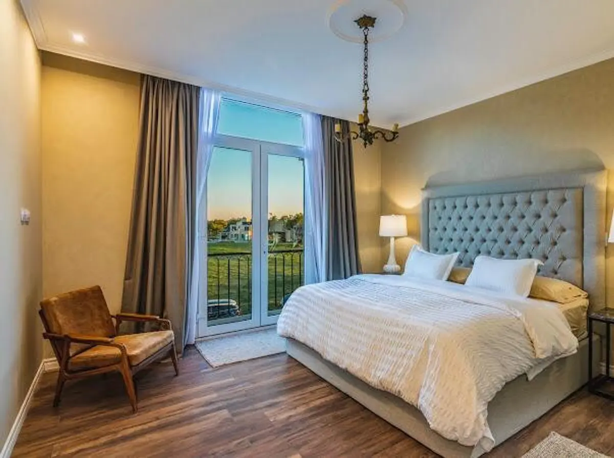 Quarto com cama grande, varanda e lustre clássico — projeto CLASICA-H3, por SCM ARQUITECTURA & CONSTRUCCIONES, em Guillermo Enrique Hudson
