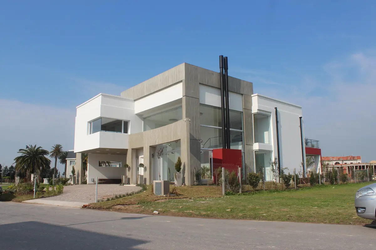 Fachada de casa moderna com grandes janelas e concreto — projeto Abierta al lago, por Marcela Romiti Arquitectura, em La Plata