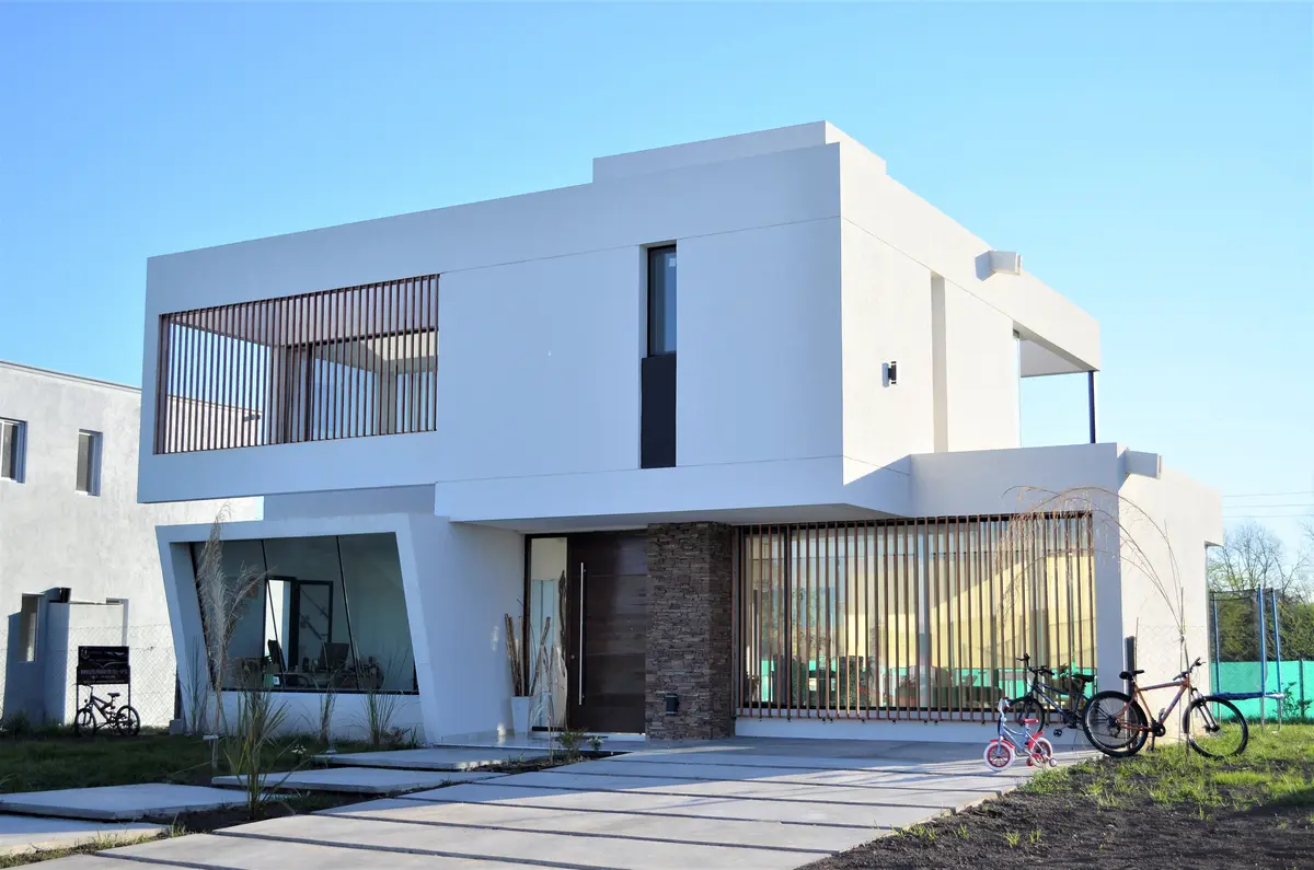 Fachada moderna branca com detalhes em madeira e grandes janelas — projeto Casa MB- Harás Sta. María, por Olivieri Arquitectura, em Haras Santa María