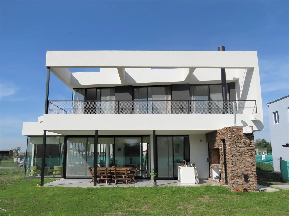Fachada moderna de casa de dois andares com detalhes em pedra — projeto Casa MB- Harás Sta. María, por Olivieri Arquitectura, em Haras Santa María