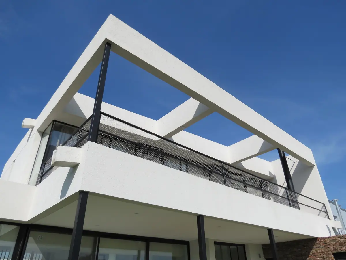 Fachada moderna com varanda de madeira e guarda-corpo preto — projeto Casa MB- Harás Sta. María, por Olivieri Arquitectura, em Haras Santa María