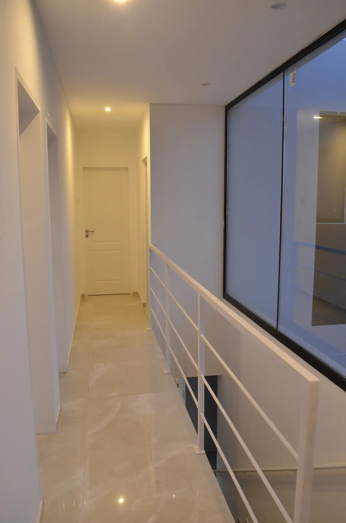 Pasillo moderno con baranda y ventanal de piso a techo — proyecto Casa MB- Harás Sta. María , por Olivieri Arquitectura, en Haras Santa María