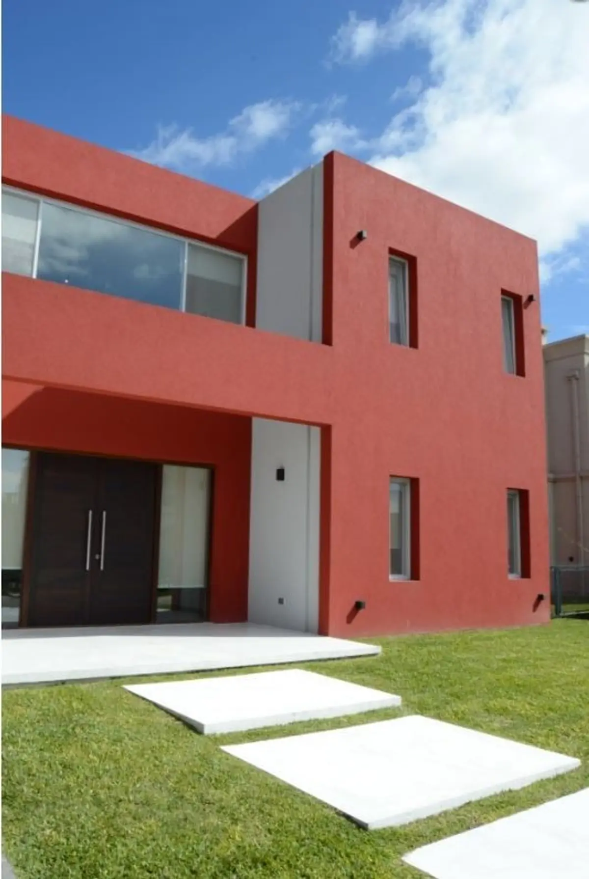 fachada moderna dos plantas color bordó con detalles blancos — proyecto Golondrinas 99, por Marcela Romiti Arquitectura, en La Plata