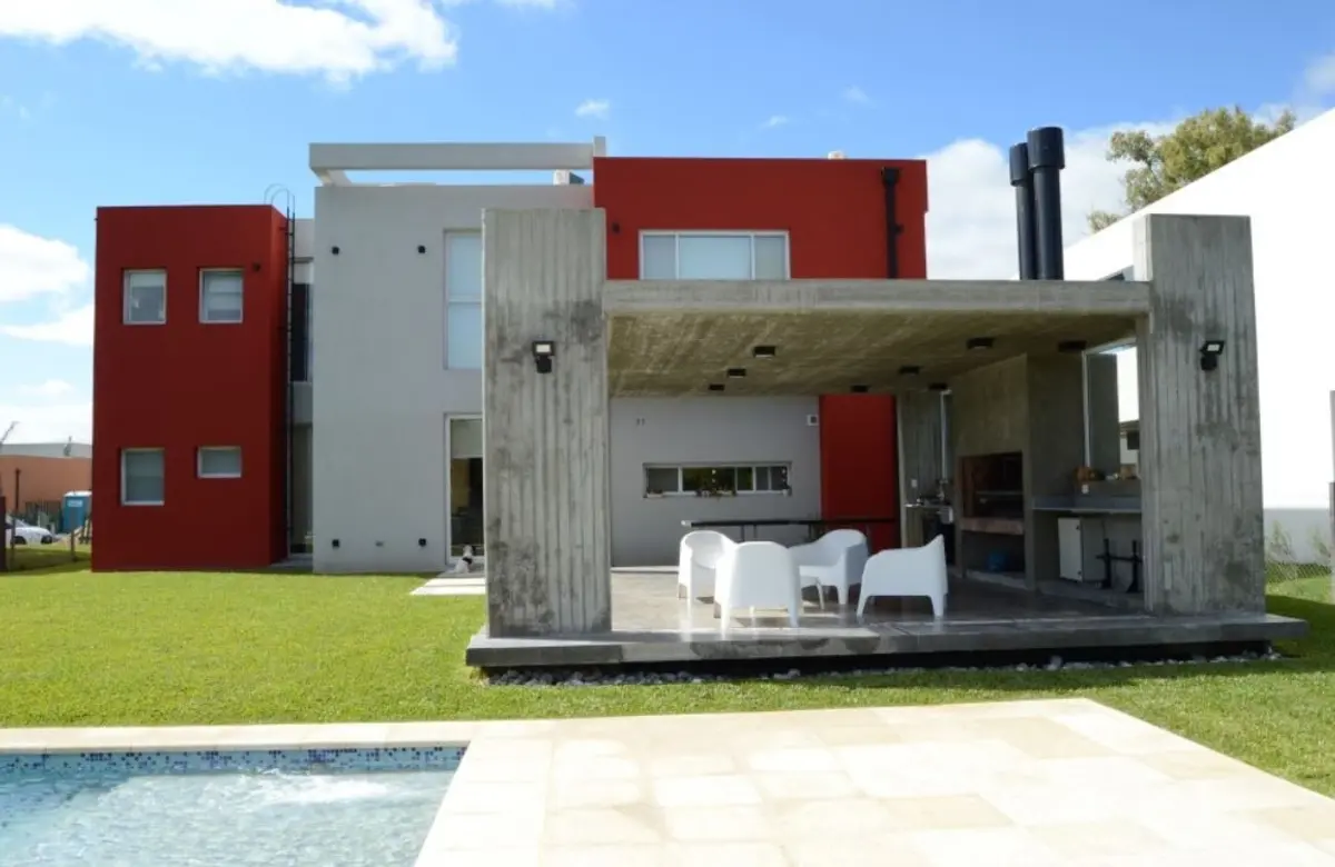 Fachada moderna com pátio externo, piscina e área de churrasco — projeto Golondrinas 99, por Marcela Romiti Arquitectura, em La Plata