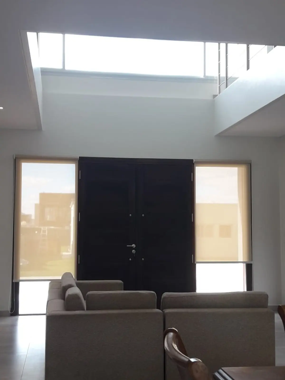 Sala de estar moderna com pé-direito duplo e claraboia grande — projeto Golondrinas 99, por Marcela Romiti Arquitectura, em La Plata