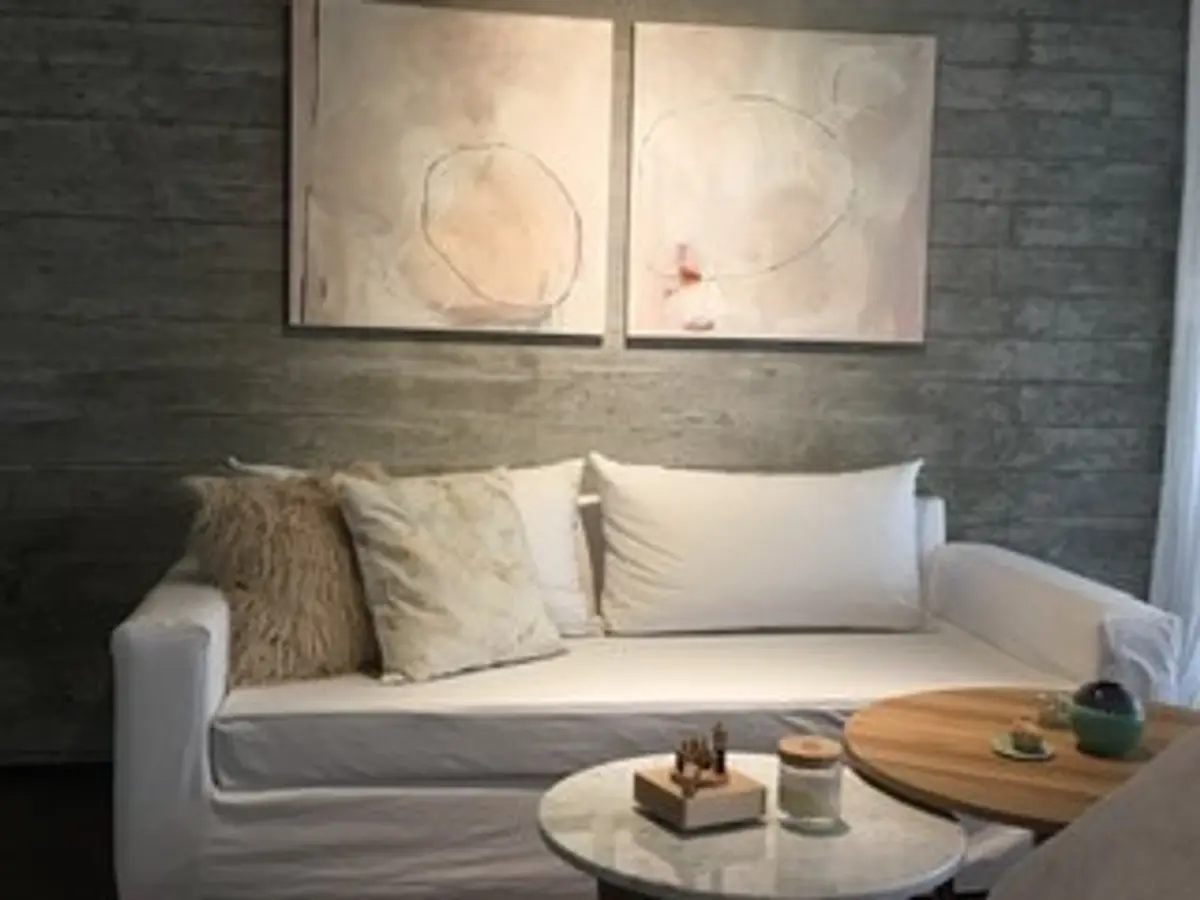 Sala de estar moderna com sofá branco, arte abstrata e parede de concreto — projeto Omm!, por Flor Martelli Diseñó y Arte, em Punta Chica