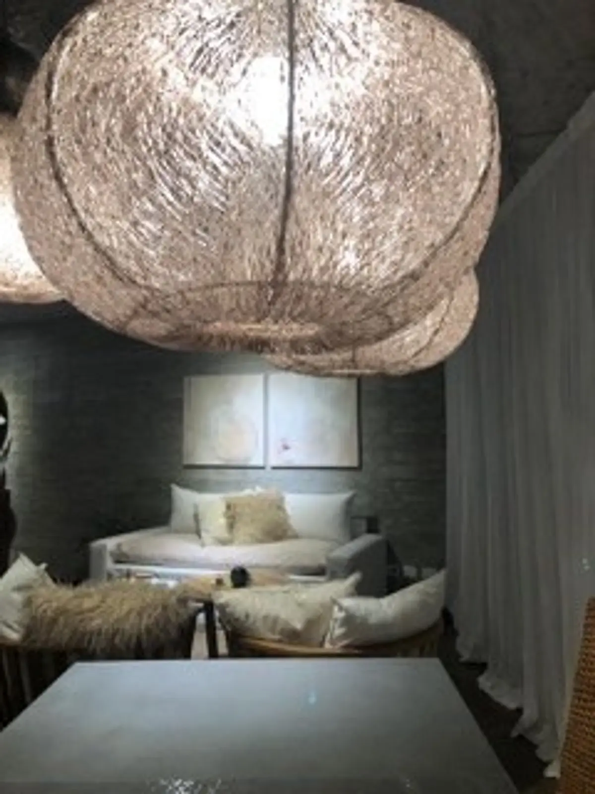 Sala con lámpara tejida gigante, sofá blanco y sillón de ratán — proyecto Omm!, por Flor Martelli Diseñó y Arte, en Punta Chica