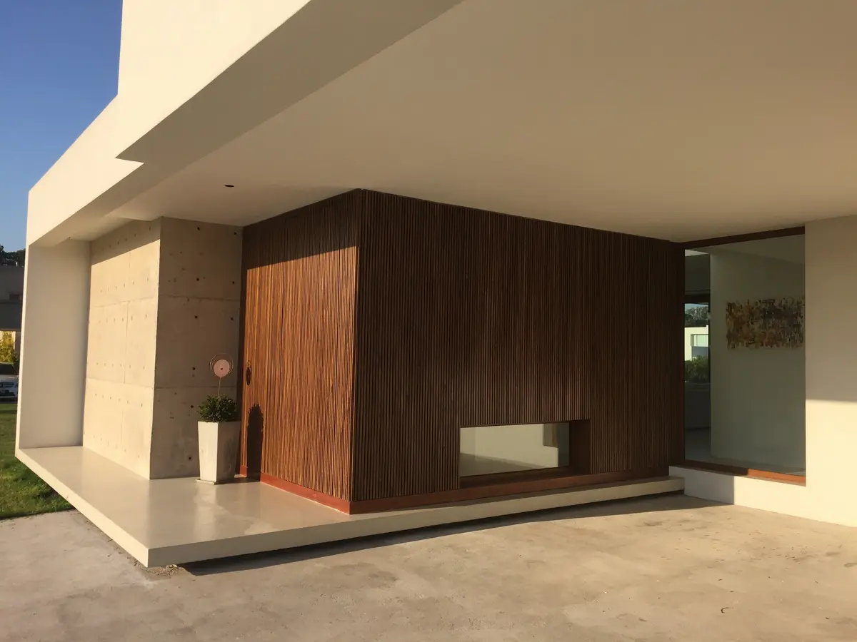 fachada moderna com revestimento de madeira e concreto — projeto VM, por Estudio GR