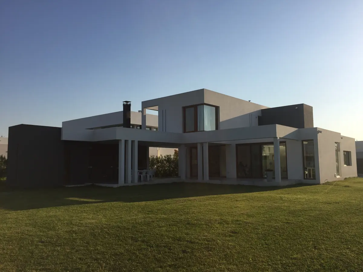 Casa moderna com amplas janelas e jardim verde — projeto VM, por Estudio GR