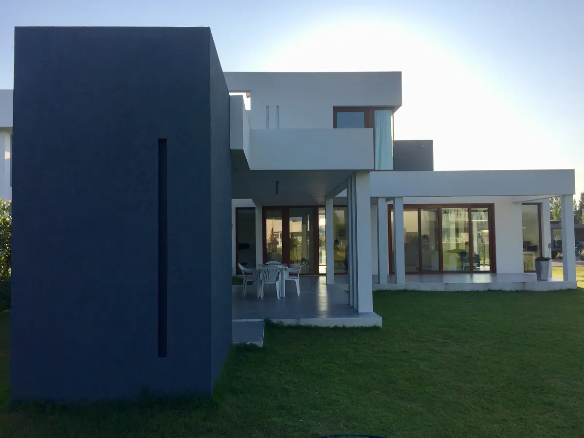 casa moderna con fachada gris y jardín verde — proyecto VM, por Estudio GR