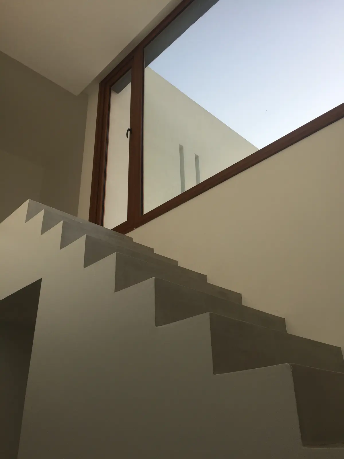 Escada flutuante de concreto com janela panorâmica — projeto VM, por Estudio GR