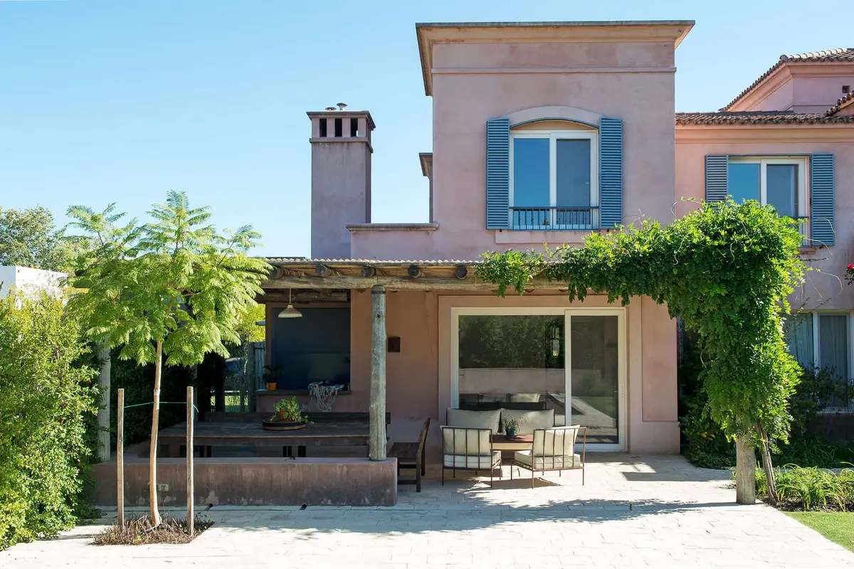Fachada de casa mediterrânea com pátio e móveis externos — projeto Casa DG, por Ricardo Pereyra Iraola