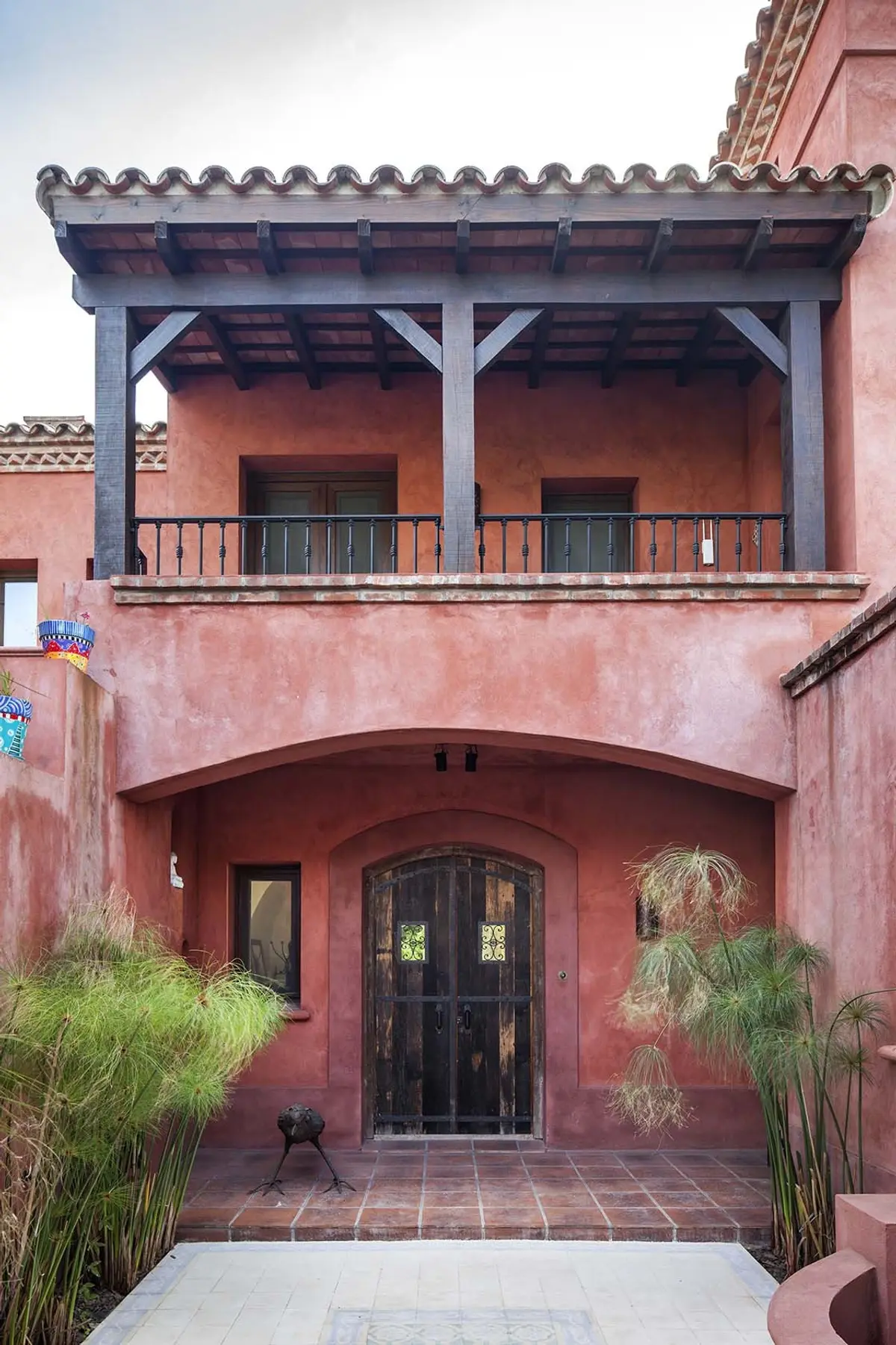 Fachada mediterrânea em estuque terracota com pérgola de madeira — projeto Rincones que Inspiran, por Ricardo Pereyra Iraola