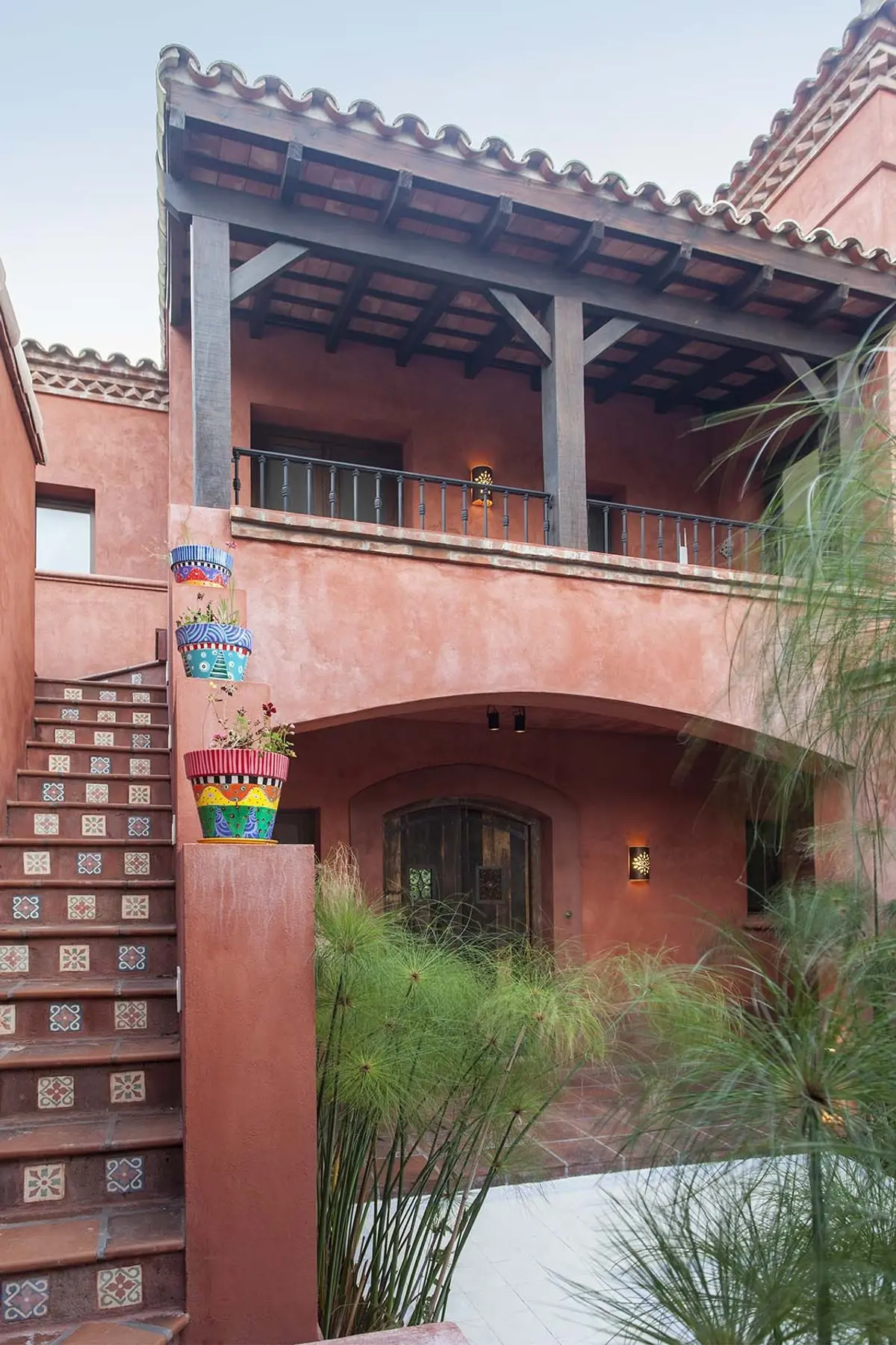 Fachada estilo Mediterrâneo com escadas e vasos coloridos — projeto Rincones que Inspiran, por Ricardo Pereyra Iraola