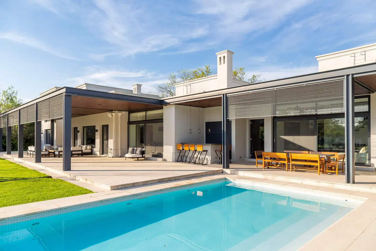 Terraza moderna con piscina, deck y parrilla — proyecto Casa IJ, por Ricardo Pereyra Iraola 