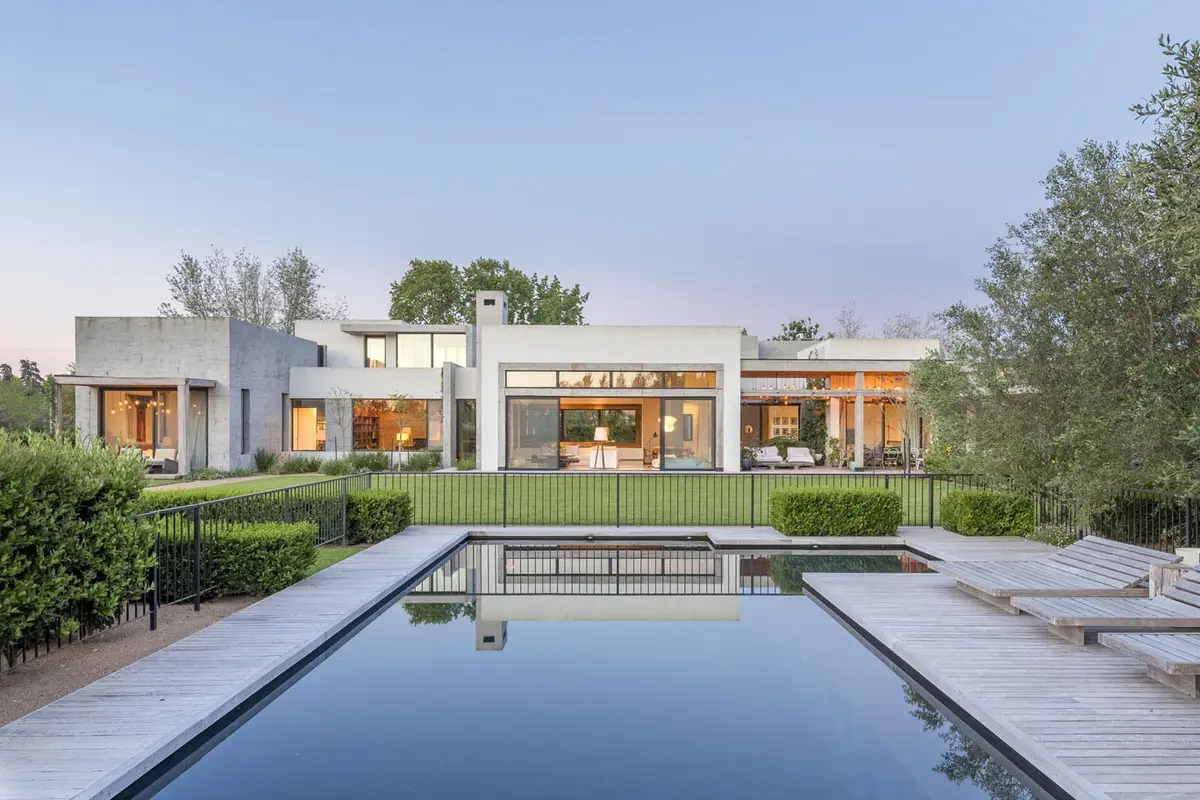 Fachada moderna con piscina infinita y terraza de madera — proyecto Hormigón, Madera y Vidrio, por Ricardo Pereyra Iraola 