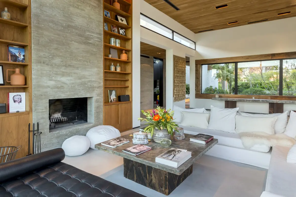 Sala de estar moderna com parede de pedra e lareira — projeto Hormigón, Madera y Vidrio, por Ricardo Pereyra Iraola