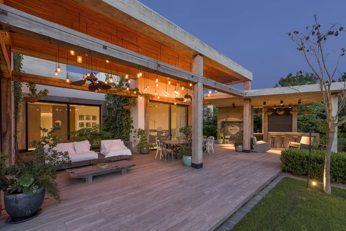 Patio moderno con deck de madera, pérgola y luces cálidas — proyecto Hormigón, Madera y Vidrio, por Ricardo Pereyra Iraola 