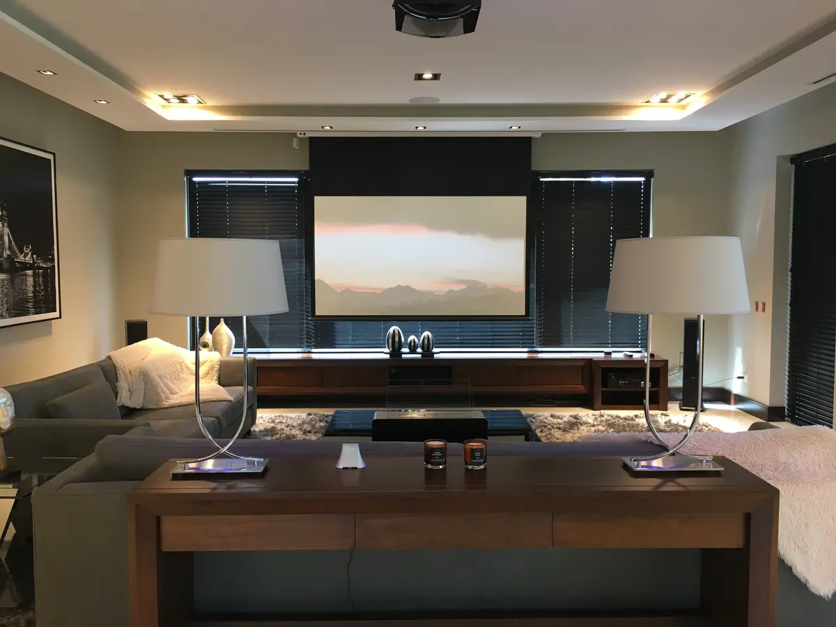Living moderno con pantalla gigante y sofás grises — proyecto Casa Abril Club de Campo, por byb.arquitectas, en Abril Club De Campo