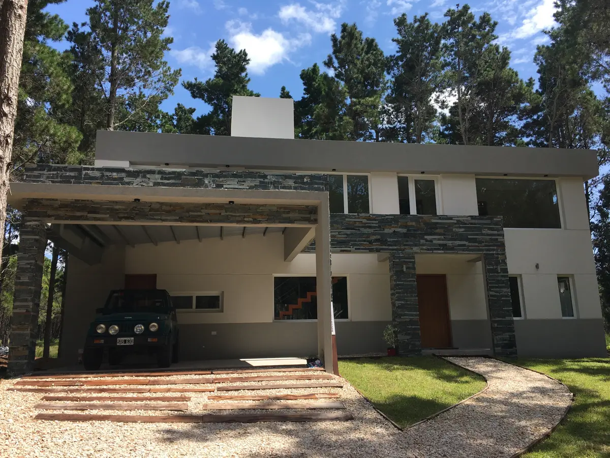 fachada de casa moderna con 볼adizo y revestimiento de piedra — proyecto Casa VR, por Sacco Maximiliano Arq., en Villa Robles