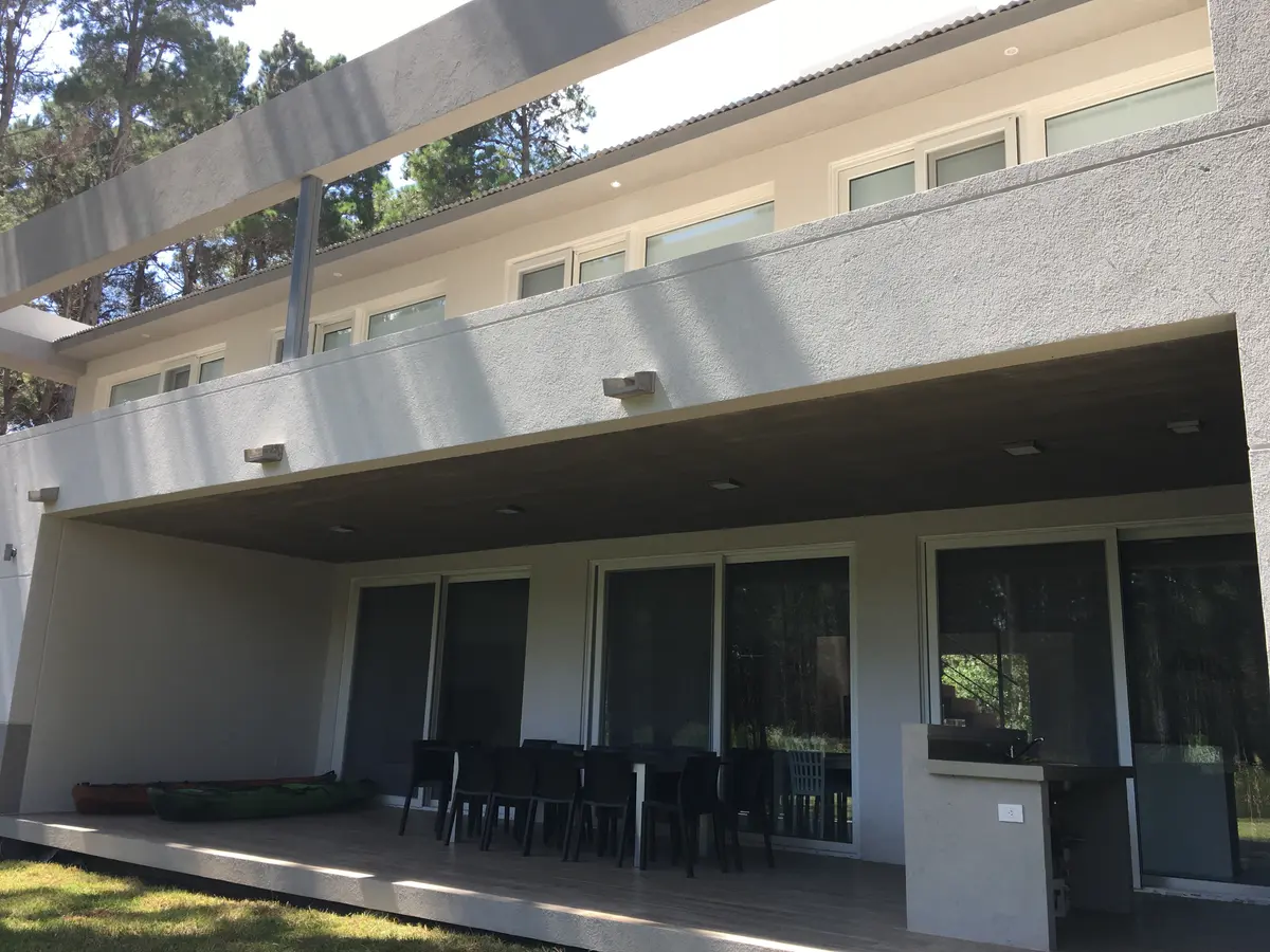 Patio moderno de casa con techo voladizo y muebles oscuros — proyecto Casa VR, por Sacco Maximiliano Arq., en Villa Robles