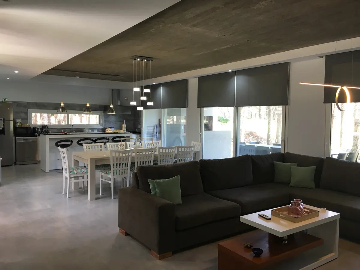 Sala de estar e cozinha moderna integrada com ilha e sofá grande — projeto Casa VR, por Sacco Maximiliano Arq., em Villa Robles