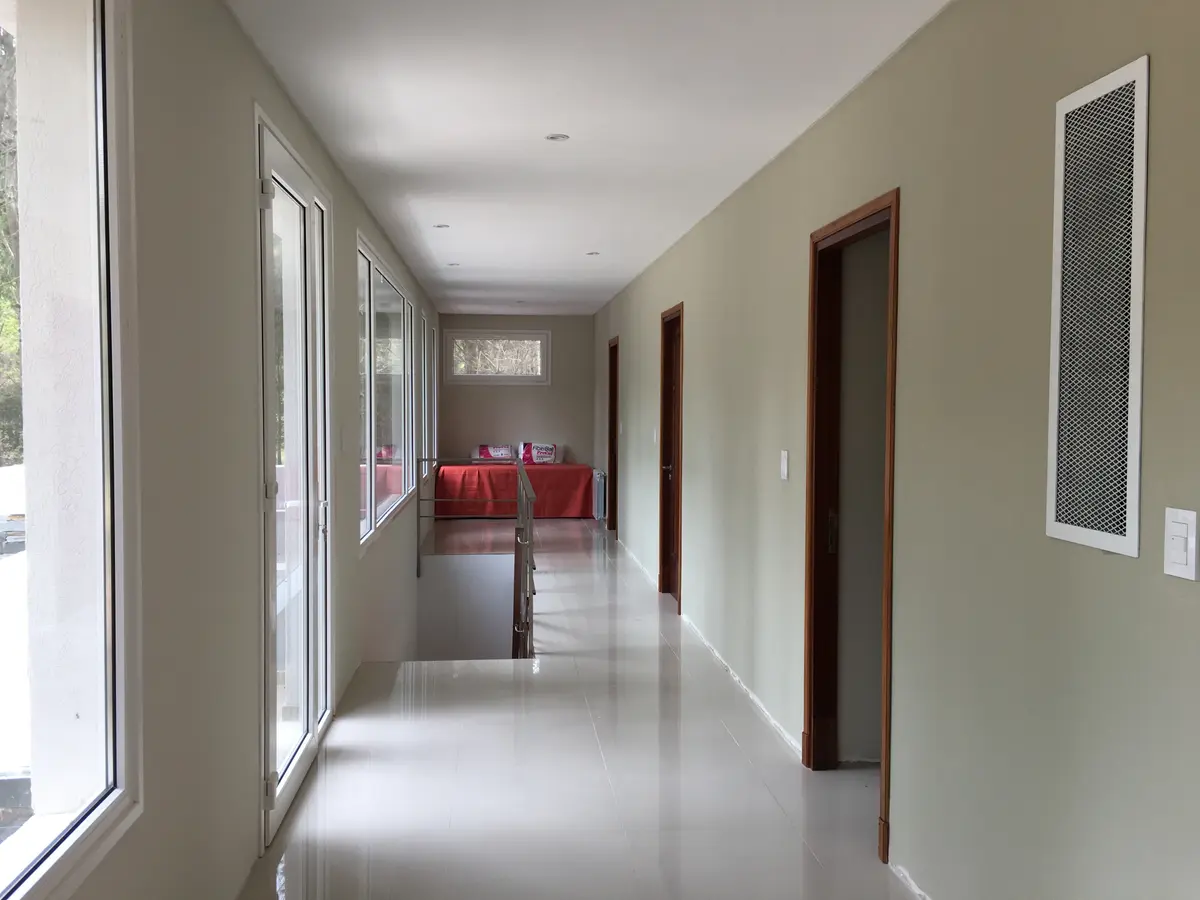 Pasillo moderno largo con ventanas amplias y luz natural — proyecto Casa VR, por Sacco Maximiliano Arq., en Villa Robles
