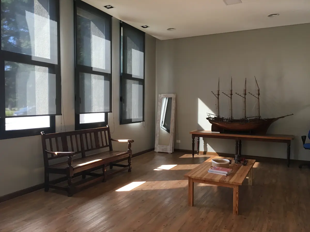 Living moderno con grandes ventanales y maqueta de barco — proyecto St George´s College Quilmes Edificio Boarding House, por byb.arquitectas, en Quilmes
