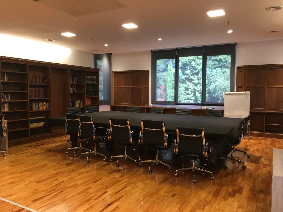Sala de reuniões ampla com painéis de madeira e mesa grande — projeto St George´s College Quilmes Edificio Boarding House, por byb.arquitectas, em Quilmes