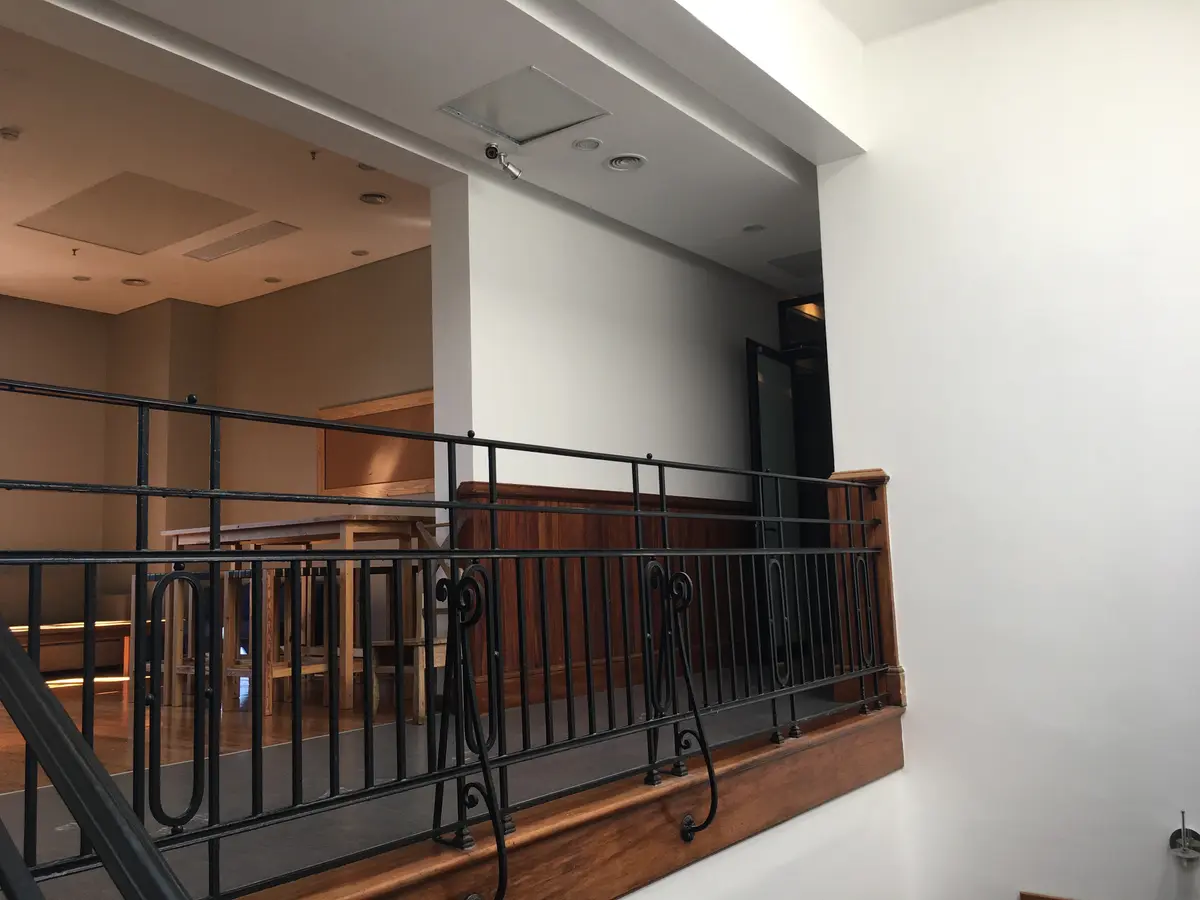 Corredor interno clássico com corrimão de metal e painéis de madeira — projeto St George´s College Quilmes Edificio Boarding House, por byb.arquitectas, em Quilmes