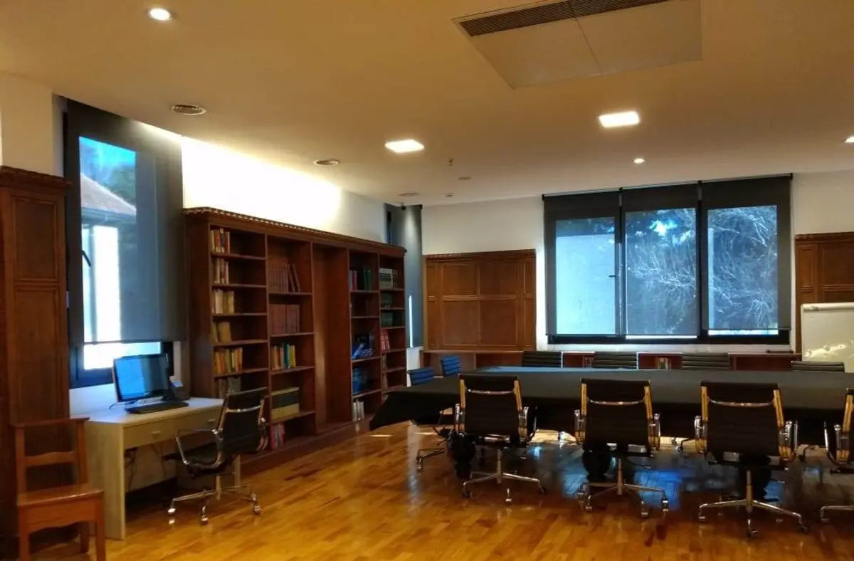 escritório amplo com estantes e mesa de reunião — projeto St George´s College Quilmes Edificio Boarding House, por byb.arquitectas, em Quilmes