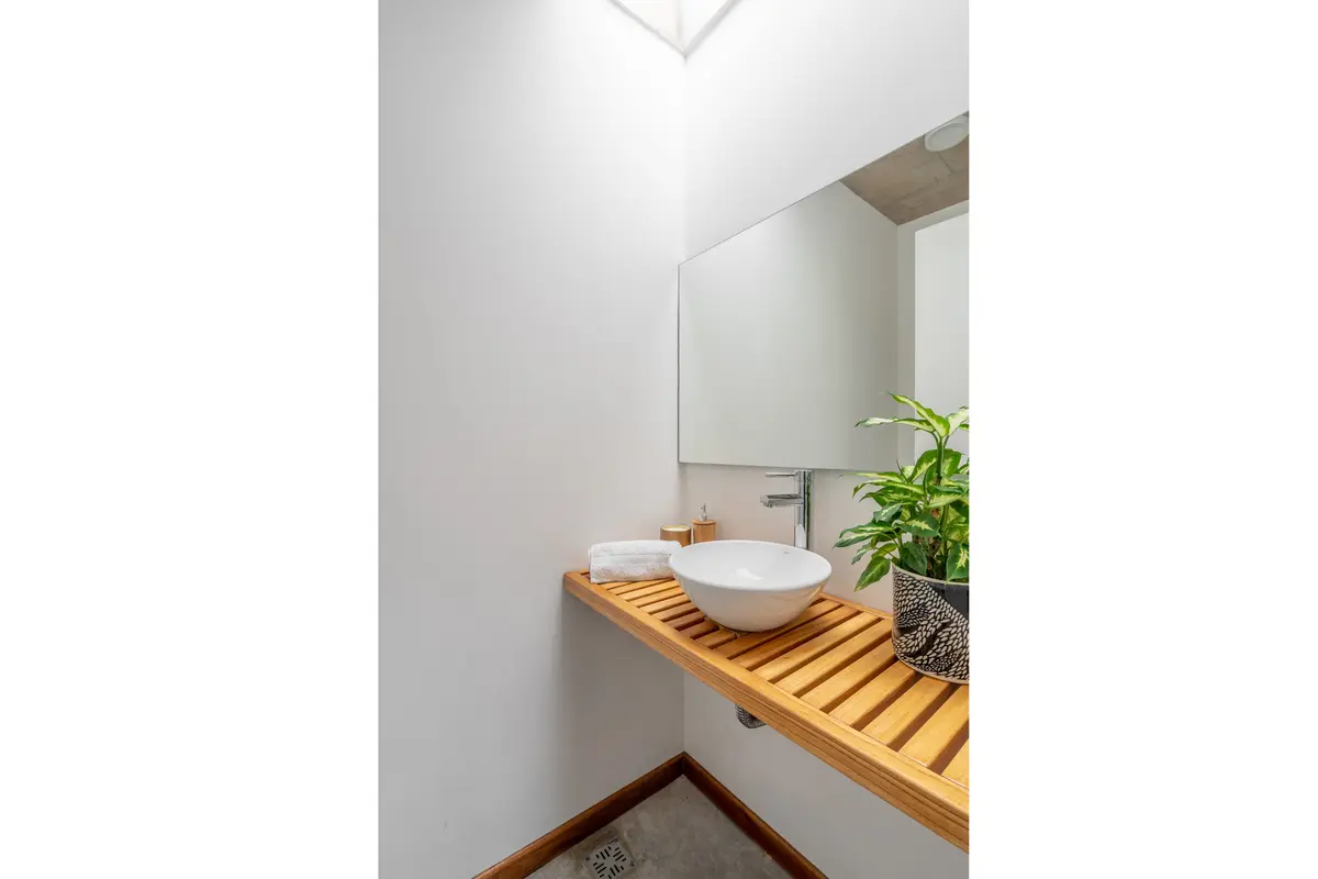 Baño moderno con bacha redonda, estante de madera y tragaluz — proyecto casa r, por GARAGE arquitectura, en Mar del Plata