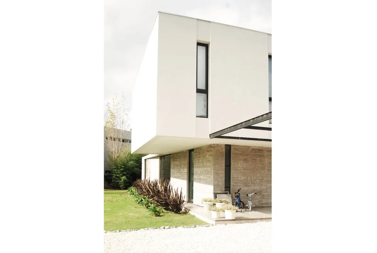 fachada moderna minimalista com detalhes em pedra — projeto casa s, por GARAGE arquitectura, em Rumencó