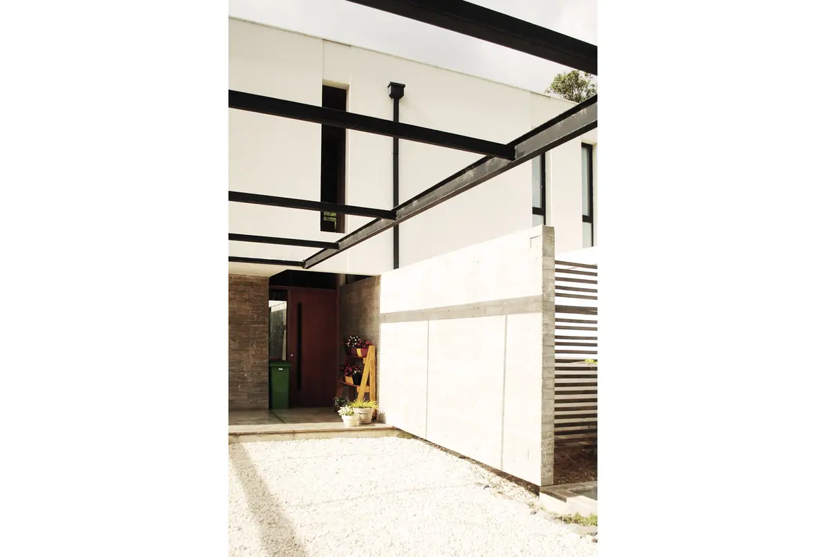 Fachada moderna con vigas expuestas y paneles blancos — proyecto casa s, por GARAGE arquitectura, en Rumencó
