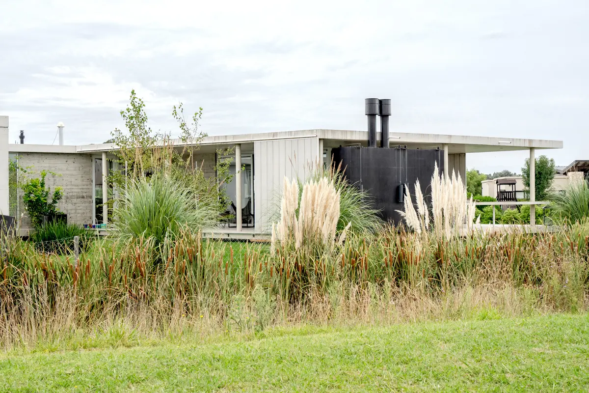 Casa moderna de concreto com capim dos pampas — projeto casa sr, por GARAGE arquitectura