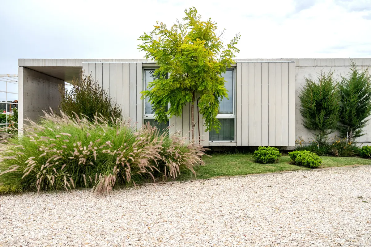 Casa moderna minimalista com grandes janelas e vegetação — projeto casa sr, por GARAGE arquitectura