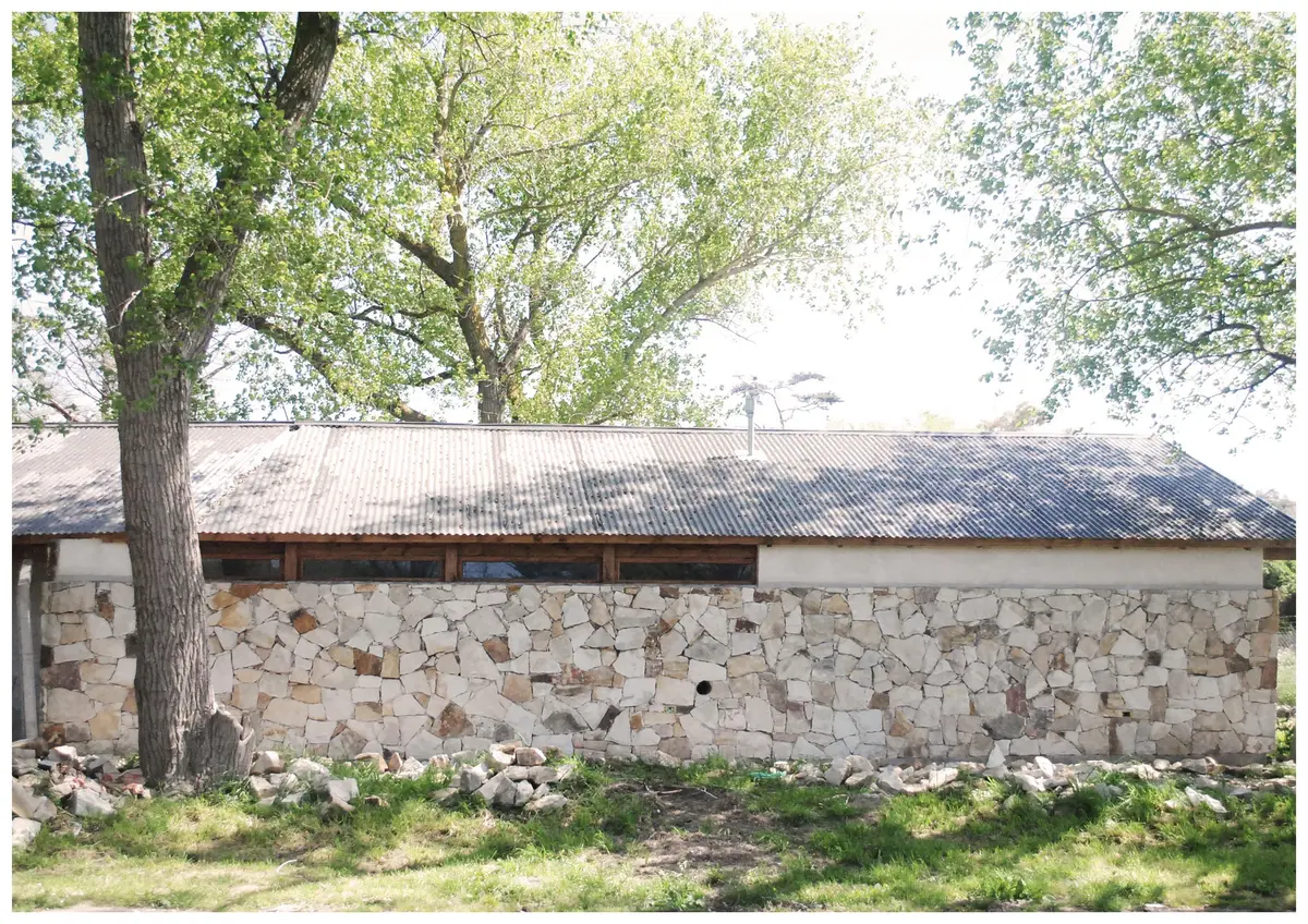 fachada rústica de pedra com telhado metálico e vegetação — projeto casa vj, por GARAGE arquitectura