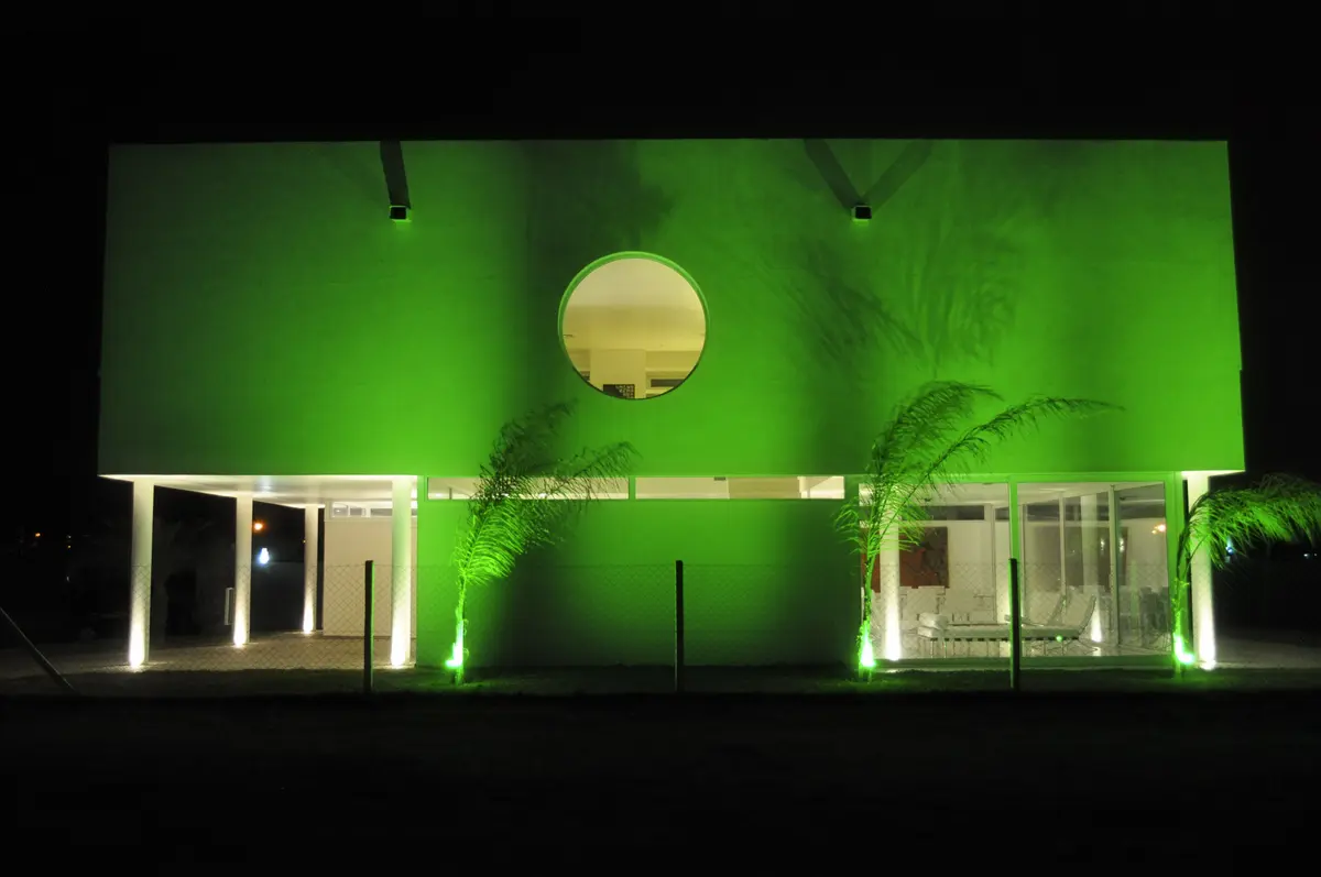 fachada moderna verde con detalles circulares iluminada de noche — proyecto CASA 120, por SCM ARQUITECTURA & CONSTRUCCIONES