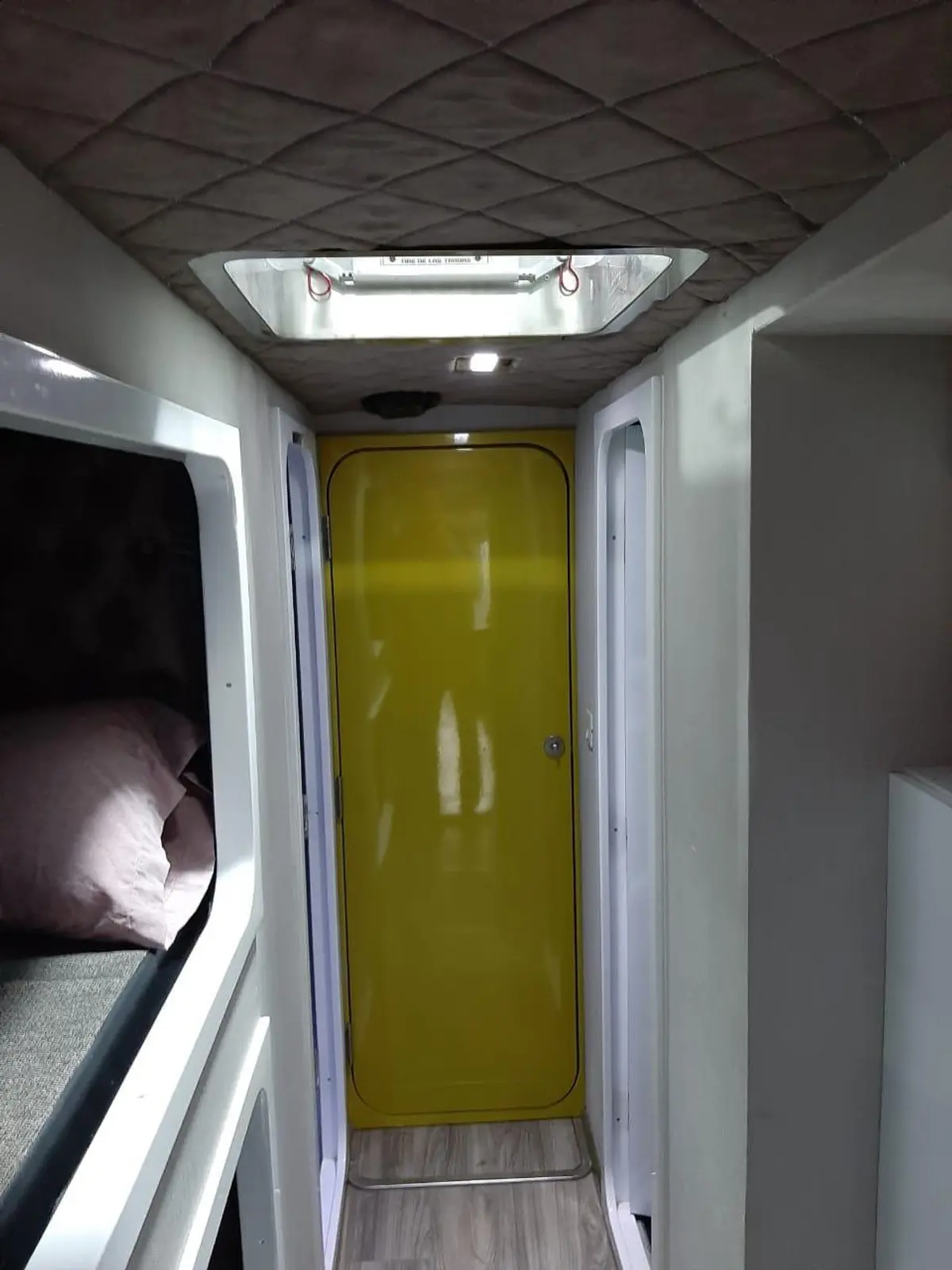 corredor interno com teto acolchoado e porta amarela brilhante — projeto MOTOR - HOME, por Estudio Arq. Carolina Peruzzo, em Mar del Plata