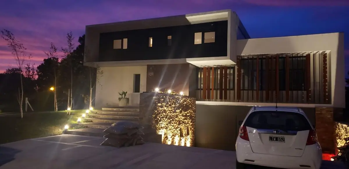 fachada moderna de casa con iluminación nocturna — proyecto Casa Rumenco, por Estudio Arq. Carolina Peruzzo , en Rumencó