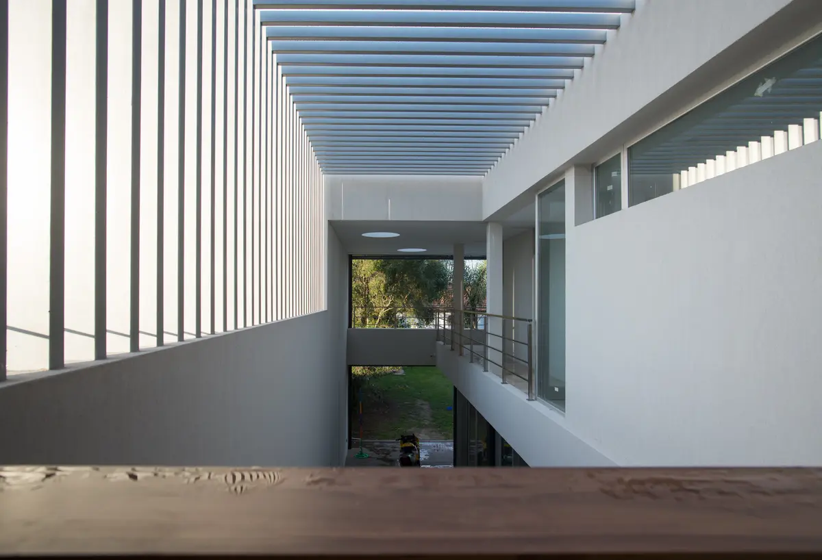 Pasillo moderno con techo de lamas y mucha luz natural — proyecto Casa Berisso, por Mercedes  klappenbach, en Berisso