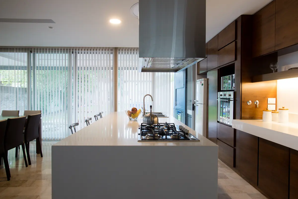 Cocina moderna minimalista con isla de mármol y vista al exterior — proyecto Casa Berisso, por Mercedes  klappenbach, en Berisso