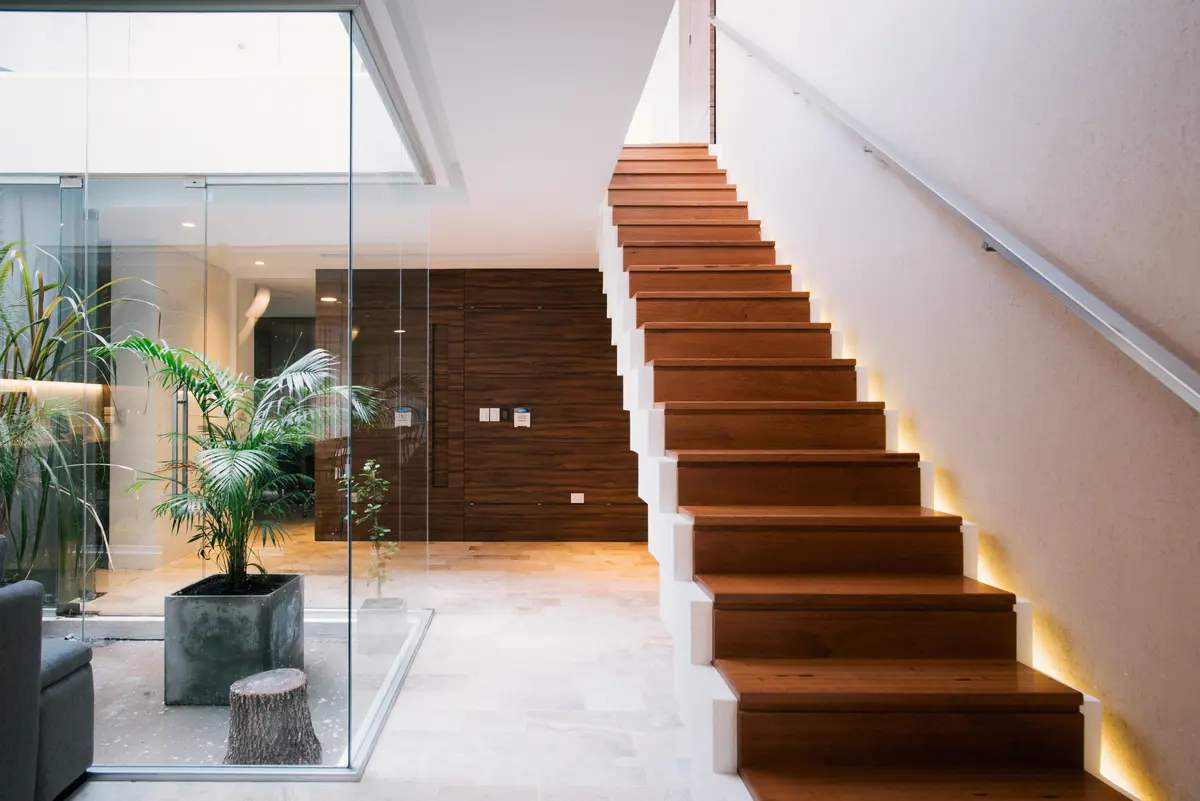 interior moderno con escalera flotante y patio interior — proyecto Casa Berisso, por Mercedes  klappenbach, en Berisso
