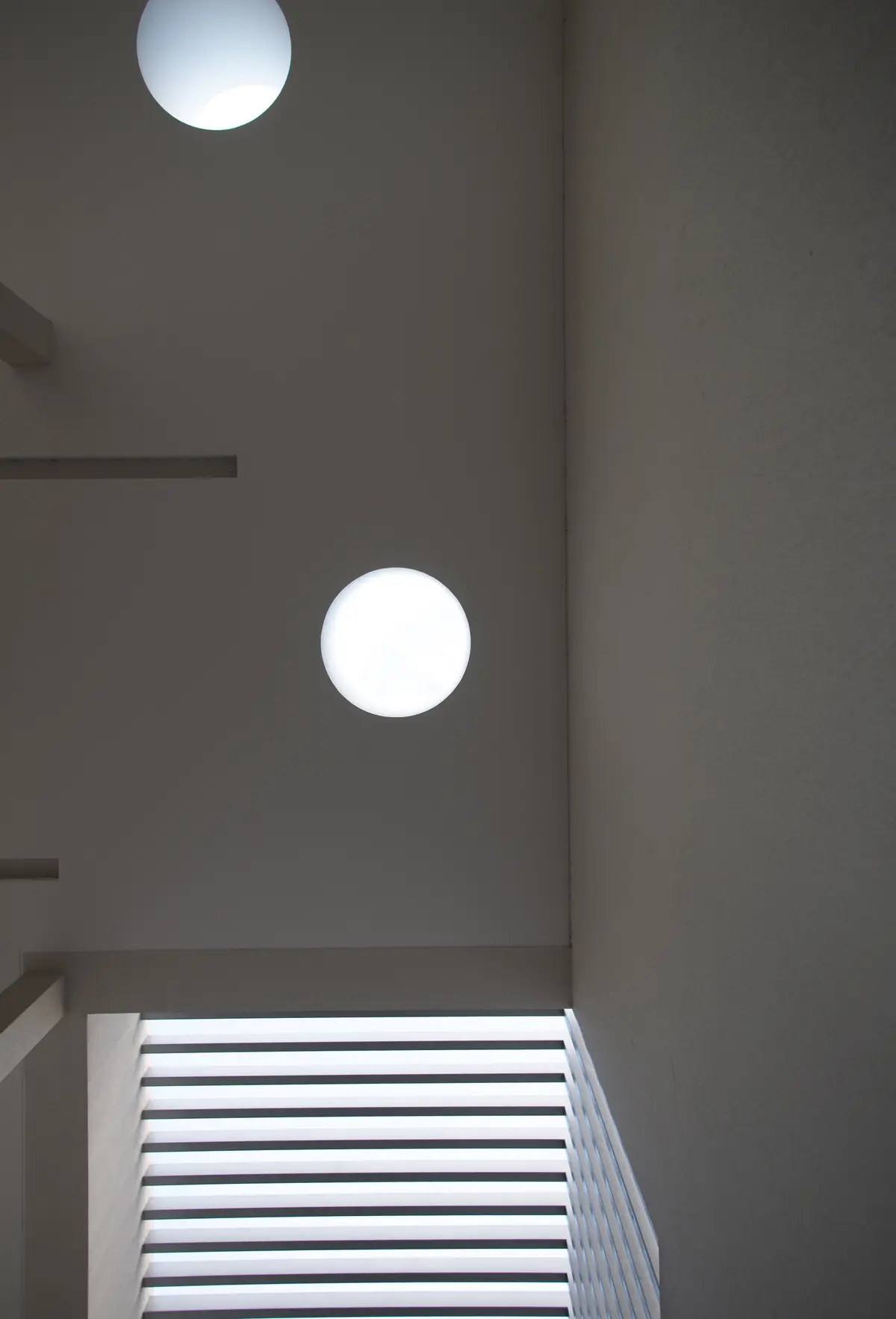Escalera minimalista con luces circulares y luz difusa — proyecto Casa Berisso, por Mercedes  klappenbach, en Berisso