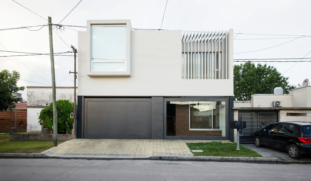 fachada de casa moderna com janelas amplas e detalhes em madeira — projeto Casa Berisso, por Mercedes  klappenbach, em Berisso